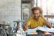 © wayhome.studio  - Creative young author with curly hair and dark skin dressed casually sitting at cafeteria preparing for writing new article in his newspaper having gentle smile on his face having good ideas in mind
