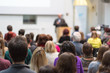 © kasto - Male speaker giving presentation in lecture hall at university workshop. Audience in conference hall. Rear view of unrecognized participant in audience. Scientific conference event.