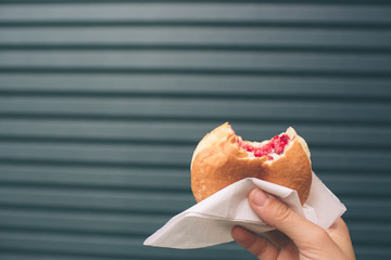 Female hand without manicure holding a donut