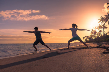 Wall Mural - Man and woman dong yoga exercise on the beach. 