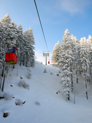 old red gondola transporting ski tourists up the mountain of Brambruesch near Chur in the Swiss Alps in winter