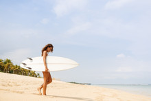 Beautiful Fit Surfing Girl In Sexy Bikini Swimwear With White Surf Shortboard Surfboard Blank Board At Sunrise Or Sunset On Sand Beach Walk To Ocean. Vacation Concept. Summer Holidays. Tourism, Sport.