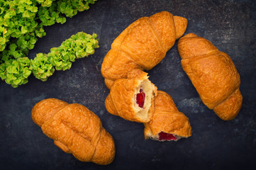 Croissants with raspberry jam. Dark blue background. Close-up. Top view