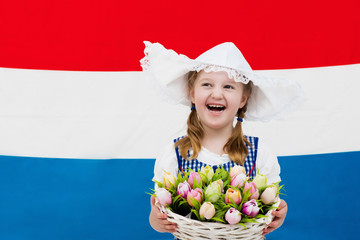 Wall Mural - Dutch child with tulip flowers and Netherlands flag