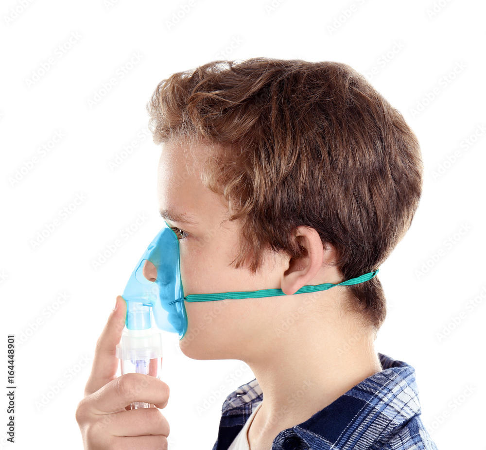 Young boy using nebulizer for asthma and respiratory diseases on white background