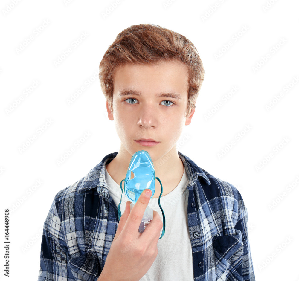 Young boy using nebulizer for asthma and respiratory diseases on white background