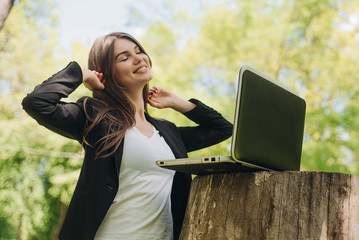 Business woman with laptop in park