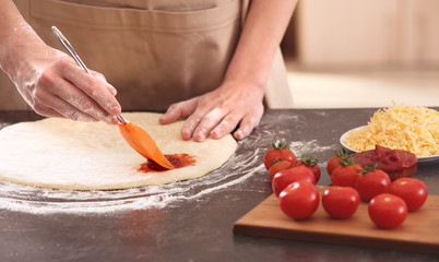 Poster - Woman preparing pizza at kitchen table