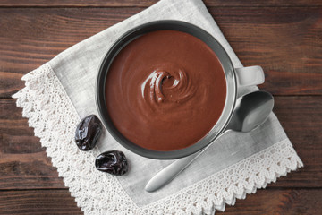 Wall Mural - Cup with delicious chocolate sauce and napkin on table