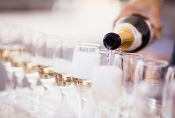 Bartender pouring champagne into glasses