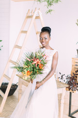 Wall Mural - Beautiful african american bride with tropical bouquet in the studio