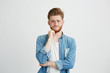 © Cookie Studio - Portrait of sad upset young guy looking at camera with hand on chin over white background.