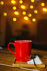 Wall Mural - Red cup of coffee in a cafe on table. Place for rest