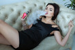 © Petro - woman smokes a e-cigarette lying on the bed in the room. Smoker's concept Vaping