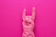 canvas print picture - hand in pink protective glove shows horns gesture. cool cleaning service concept