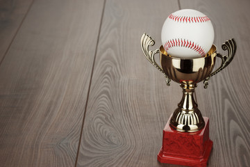 Wall Mural - golden baseball trophy cup on the wooden table