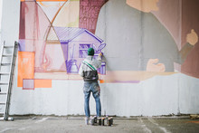 Graffiti Artist Painting On The Wall