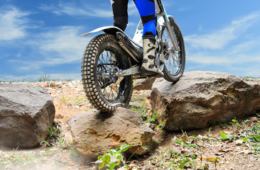 Wall Mural - Trials motorcycle is jumping over rocks