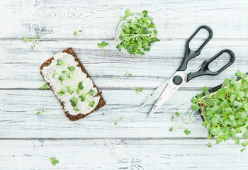 Poster - Wooden table with healthy food (slice of bread, cream cheese and fresh cutted cress)