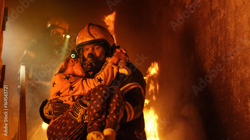 Brave Fireman Descends Stairs of a Burning Building and Holds Saved Girl in His Arms Tableau sur Toile