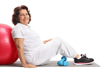 Poster - Mature woman with a pilates ball and dumbbells