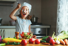 Healthy Eating. Happy Child Girl Prepares  Vegetable Salad In Kitchen