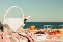 Summer Time At The Sea. Romantic Picnic On The Beach - Wine, Strawberries And Sweets.