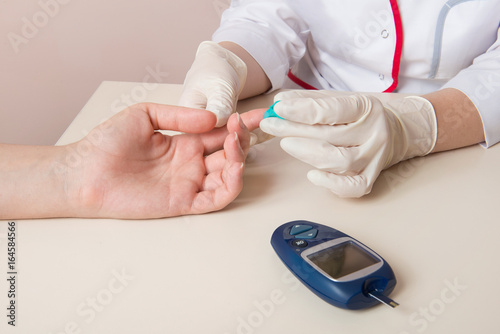Fotomural doctor measuring glucose level blood in hospital