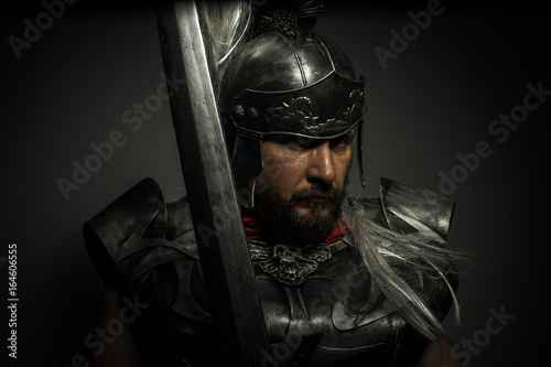 Fotografía Gladiator, Roman centurion with armor and helmet with white chalk, steel sword a