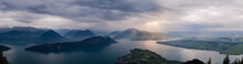 Panorama View Of Quatre Cantons Lake In Luzern, Switzerland, With A Storm Sky Reflection On Water.