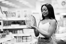 Gorgeous African American Woman Holding A Silver Vase In The Shop. Black And White Photo.