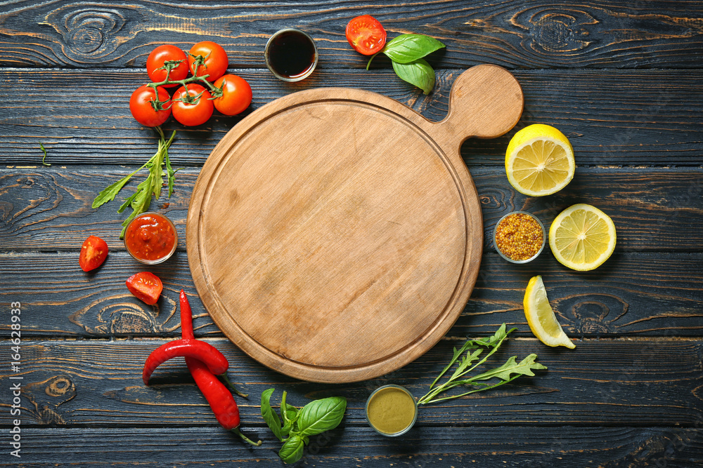 Wooden board, different sauces and vegetables on table