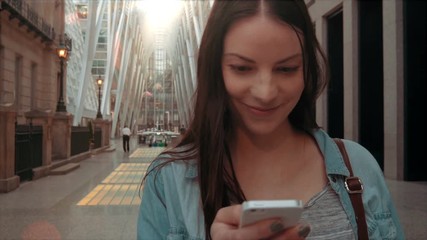 pretty woman texting in her phone at an upscale shopping mall