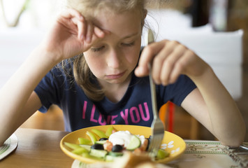 Little girl don't want to eat meal in restaurant.