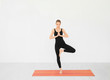 © Africa Studio - Young beautiful woman practicing yoga pose near white wall indoors