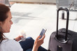 © Song_about_summer - woman passenger using mobile internet or wifi on her smartphone in the airport or modern train station
