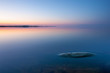 Tranquil minimalist landscape with rock in calm water