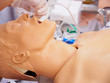 Close-up side shot of a physician practicing the placement of a nasogastric (NG) tube on a plastic dummy. Healthcare and medical education concept.