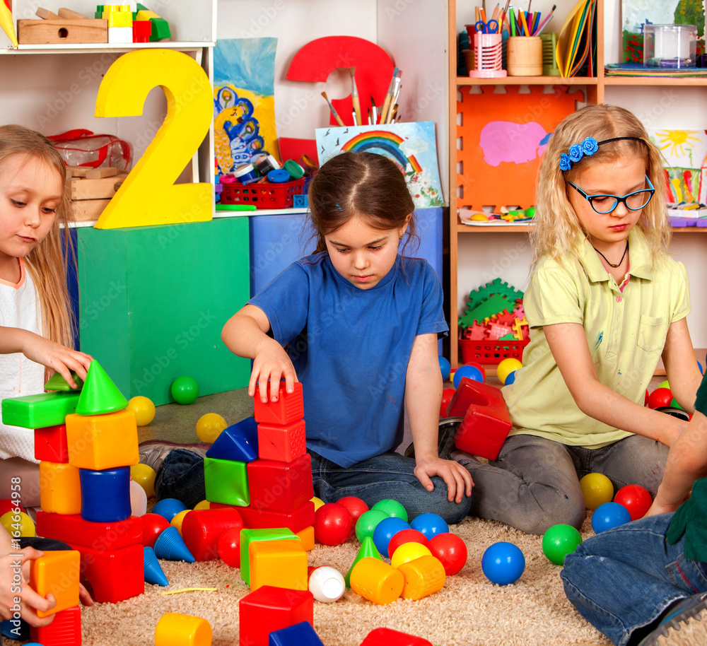 Children building blocks in kindergarten. Group kids playing toy on floor.  Children develop their fingers in a game of cubes number one. Stock Photo |  Adobe Stock, image size:1000x914