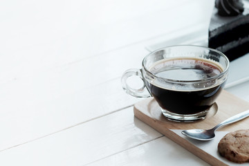 hot americano black coffee and A piece of charcoal cake on white wooden table. Have some space foe write wording