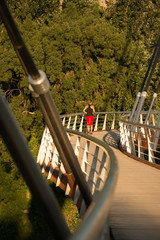 Beautiful woman running over bridge in the morning