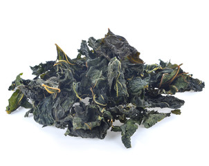 Heap of dry tea with green tea leaves isolated on a white background.