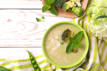 Wall Mural - Broccoli and green peas puree soup decorated with mint