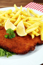 Dish Of Wiener Schnitzel And French Fries Served With Sauces And