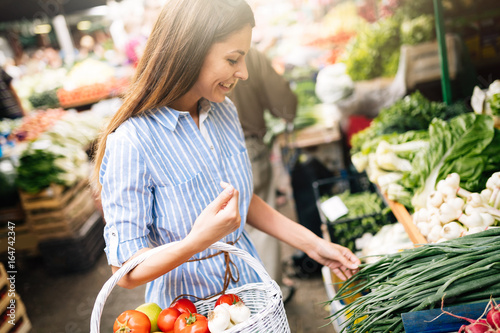 Fotografía Picture of woman at marketplace buying vegetables