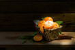 Still Life Orange in basket light in the dark on a wooden table