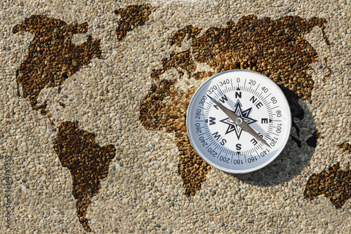 Plakat Kompas i mapa świata na małym żwirowym kamieniu, znajdź właściwą drogę dla naszej ziemskiej koncepcji