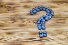 Question Mark Maked Of Fresh Ripe Natural Blueberries On A Brushed Wooden Background. Healthy Diet  Question Concept