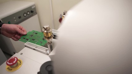 Poster - A board with processors. Man uses an electronic Board