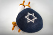 Judaism and jewish religious holiday concept with a closed Torah and a kippah also called a yamaka. Some of the better known jewish holidays are Tisha B'Av, Purim, Hannukah, Yom Kippur, etc